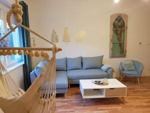 a living room with a blue couch and a hammock at MoryńApartments in Moryń +48 photos