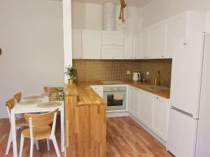 a kitchen with white cabinets and a table and chairs at MoryńApartments in Moryń
