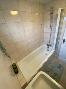 uma banheira branca na casa de banho com uma janela em NEC/Airport/HS2/Resorts World em Marston Green