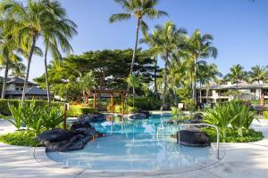 een zwembad in een resort met palmbomen bij Hilton Pool Pass Included - Luxury Living on the Green w Pool Hot Tub & Views in Waikoloa