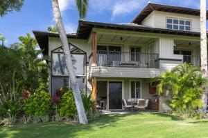 een huis met een balkon en palmbomen bij Hilton Pool Pass Included - Luxury Living on the Green w Pool Hot Tub & Views in Waikoloa