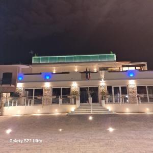 a white building with blue lights at night at La Maison du Port in Lazise