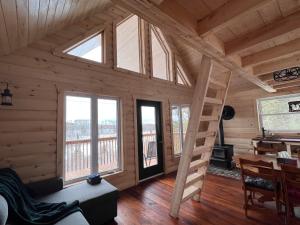 una habitación con una escalera en una cabaña de madera en Les Racines du p'tit Isidore, en Rouyn