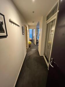 a hallway leading to a room with a door and a room with a hallway at The One Grand Prix Living in Melbourne