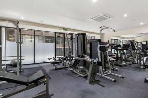 a gym with several treadmills and machines in it at The One Grand Prix Living in Melbourne
