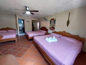 a bedroom with two beds and a ceiling fan at Residencial El Valle in Valle de Anton