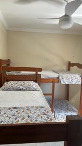 a room with three bunk beds and a ceiling at POUSADA ONDA CARIOCA in Cabo Frio