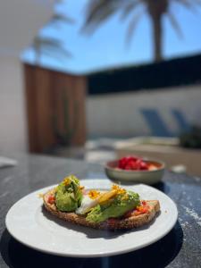 a piece of bread with broccoli on a white plate at TenSuites - Adults Only in Maspalomas