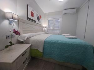 a white bedroom with a large bed and a desk at Atico Gran Boulevard de Albacete - A 5 minutos de la Feria in Albacete