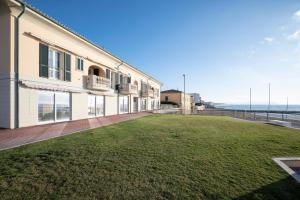 ein Gebäude mit einem großen Rasen davor in der Unterkunft Suite vista mare in San Vincenzo