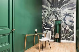 a room with green walls and a glass table and chair at La Pittoresque 1 in Carcassonne