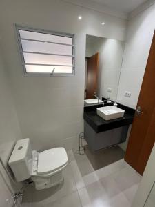 łazienka z toaletą i umywalką w obiekcie Casa Nova - Excelente Localização w mieście Piracicaba