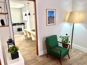 a living room with a green chair and a table at Casa Cozy - Excelente Localização in Piracicaba