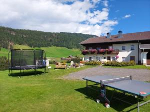 un tavolo da ping pong in un cortile accanto a una casa di Ferienhaus Köck a Kartitsch