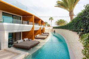 a swimming pool in front of a building at TenSuites - Adults Only in Maspalomas