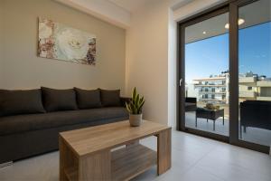 uma sala de estar com um sofá e uma mesa em Ruby Luxury Suites em Chania Town