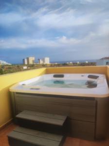 a bath tub with a view of a city at Pendhous Sabina mit Jacuzzi in Callao Salvaje