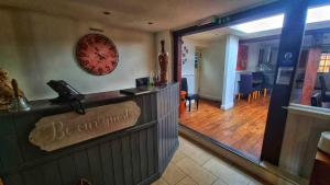 a restaurant with a bar with a clock on the wall at The George & Dragon Hotel in Long Melford +7 photos