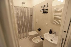 a white bathroom with a toilet and a sink at Santa Chiara Luxury House in Naples