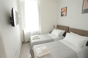 two beds in a small room with a tv at Santa Chiara Luxury House in Naples