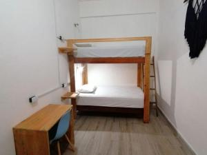 a small room with two bunk beds and a desk at Casa Tortuga Azul in Palenque