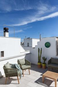 a patio with chairs and tables on a roof at Casa Antica Pietra Ostuni in Ostuni