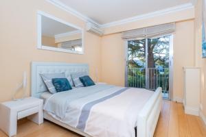 um quarto branco com uma cama grande e uma janela em PRESTIGE Mont Boron -Terrace -Sea View -2BR em Nice