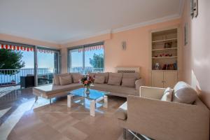 uma sala de estar com um sofá e uma mesa em PRESTIGE Mont Boron -Terrace -Sea View -2BR em Nice