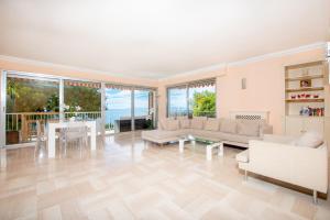 ein Wohnzimmer mit Sofas, einem Tisch und Stühlen in der Unterkunft PRESTIGE Mont Boron -Terrace -Sea View -2BR in Nizza