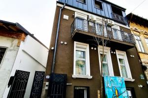 een bruin gebouw met een balkon aan de zijkant bij Modern & Comfortable Apartament Cismigiu Park - POP3 in Boekarest