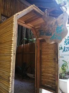 a wooden entrance to a building with a sign on it at Casa Tortuga Azul in Palenque