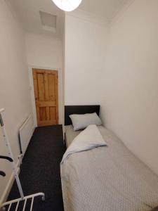 a small bedroom with a bed and a door at Church View house,2bed,brighouse central location in Brighouse