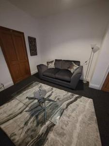a living room with a couch and a glass table at Church View house,2bed,brighouse central location in Brighouse