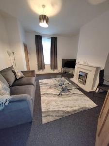 a living room with a couch and a fireplace at Church View house,2bed,brighouse central location in Brighouse