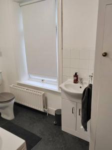 a white bathroom with a toilet and a sink at Church View house,2bed,brighouse central location in Brighouse