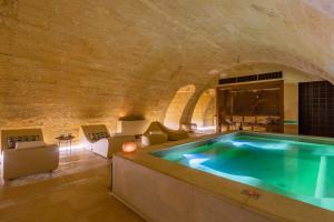 uma casa de banho com uma banheira de hidromassagem numa parede de tijolos em Palazzo Maresgallo Suites & SPA em Lecce