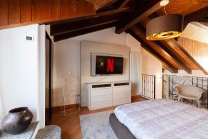 Schlafzimmer mit einem Bett und einem TV an der Wand in der Unterkunft Casa del Borgo - Esclusiva Suite centro Monza con vista Duomo in Monza