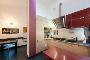 a kitchen with brown cabinets and a red counter top at ROSA DEI VENTI in Santa Margherita Ligure +6 photos