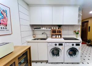 a kitchen with a washing machine and a sink at ARA125 in Seoul
