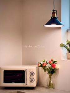 a microwave sitting next to a vase of flowers at ARA125 in Seoul