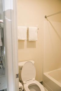 a bathroom with a toilet and a tub and towels at Exclusive Quarters in Cleveland