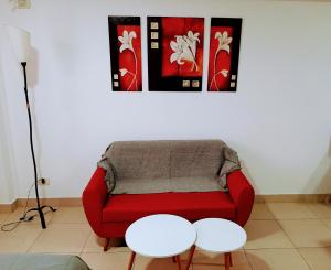 sala de estar con sofá rojo y 2 mesas en Catamarca Río en Rosario
