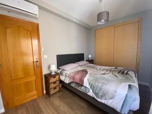 a bedroom with a bed and a wooden door at Arenales Sol y Playa Les Dunes in Arenales del Sol