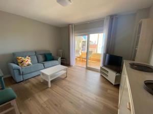 ein Wohnzimmer mit einem Sofa und einem TV in der Unterkunft Arenales Sol y Playa Les Dunes in Arenales del Sol