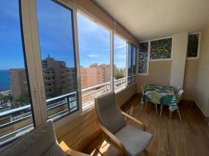 a balcony with a table and chairs and large windows at Arenales Sol y Playa Les Dunes in Arenales del Sol