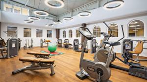 a gym with treadmills ellipticals and exercise bikes at Dorint MARC AUREL Spa & Golf Resort in Bad Gögging