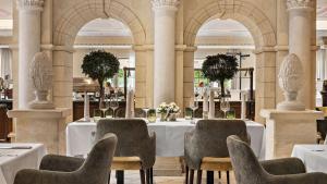 a dining room with tables and chairs and columns at Dorint MARC AUREL Spa & Golf Resort in Bad Gögging