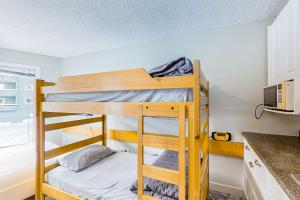 two bunk beds in a small room with a kitchen at Whitefoot Lodge 314 in Big White