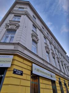 un edificio blanco y amarillo con un letrero. en 4 seasons apartment, en Viena