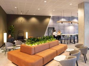 a lobby with a couch and chairs and a bar at Novotel Liverpool Paddington Village in Liverpool